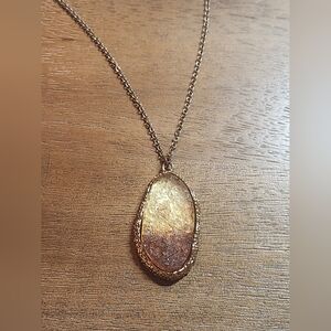 Gold tone statement necklace with a big pendant and long chain